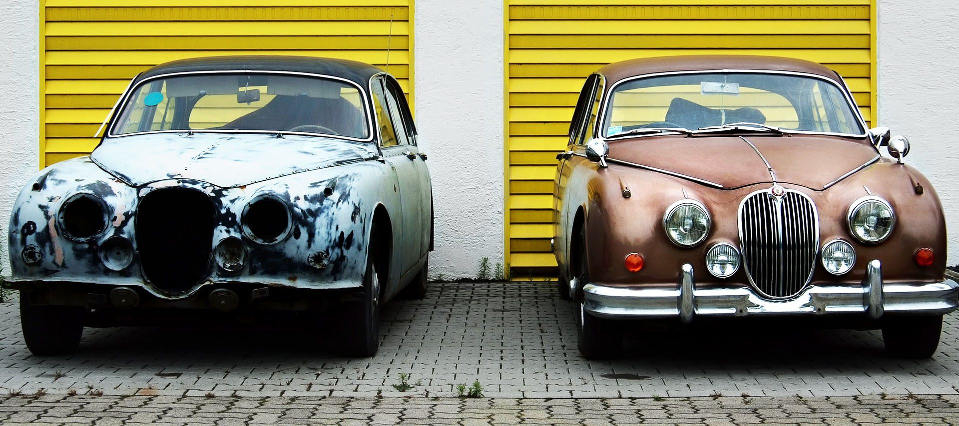 altes und neues Auto vor Garagen